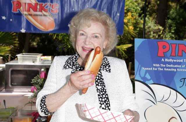 Betty White hält einen Hot Dog im Freien