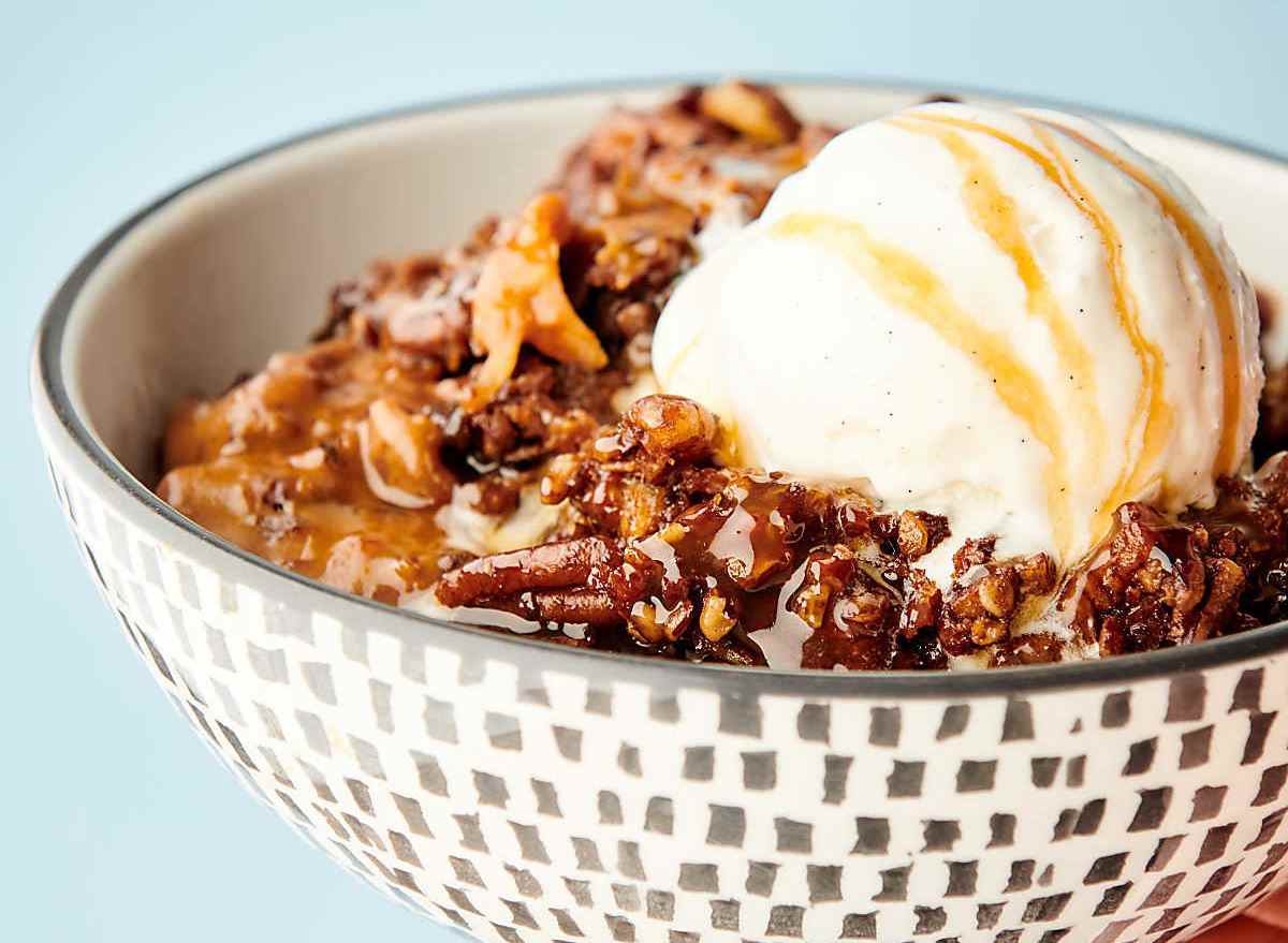 slow cooker carrot cake topped with vanilla ice cream in bowl