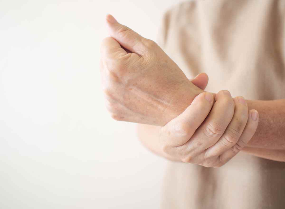 ältere Frau mit Handgelenk mit Gelenkschmerzen schlechte Knochengesundheit