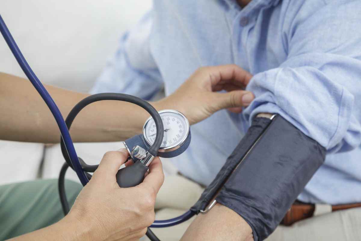 Krankenschwester, die den Blutdruck eines älteren Mannes misst