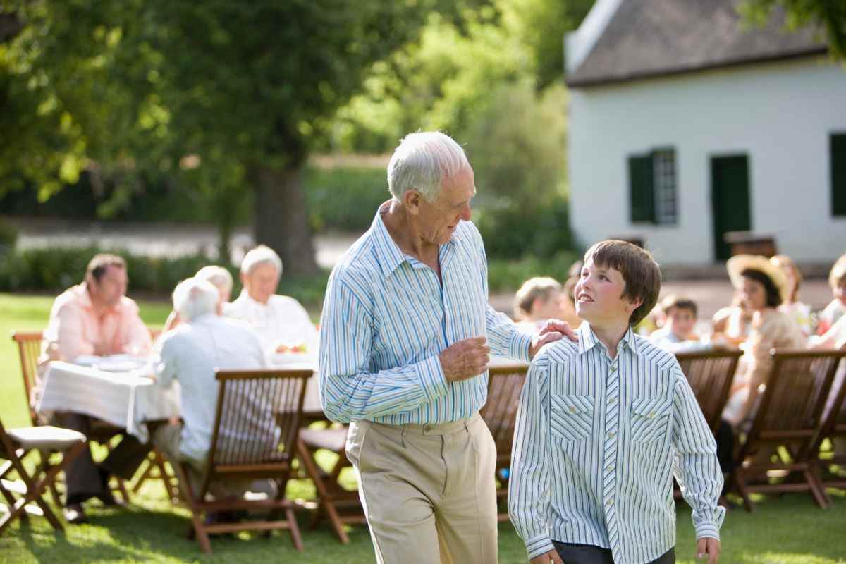 Ein Großvater unterhält sich mit seinem Enkel auf einer Party