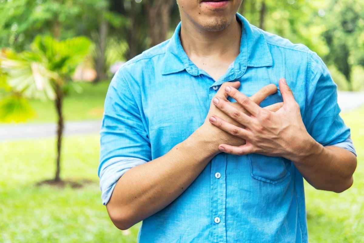 Mann, der Händchen an der Brust hält, leidet an Herzinfarkt