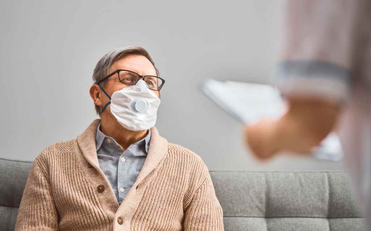 Arzt und leitender Mann, der während des Ausbruchs von Coronavirus und Grippe Gesichtsmasken trägt