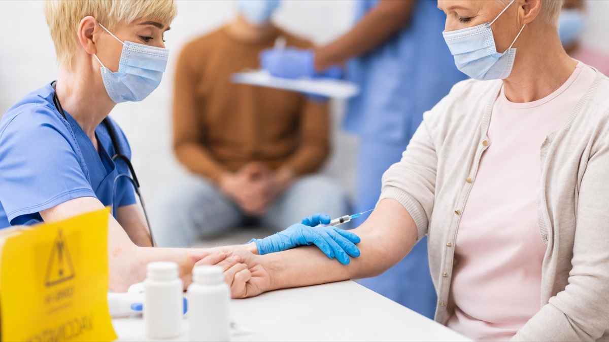 Arzt gibt einer älteren Frau eine Impfung gegen das Corona-Virus im Krankenhaus