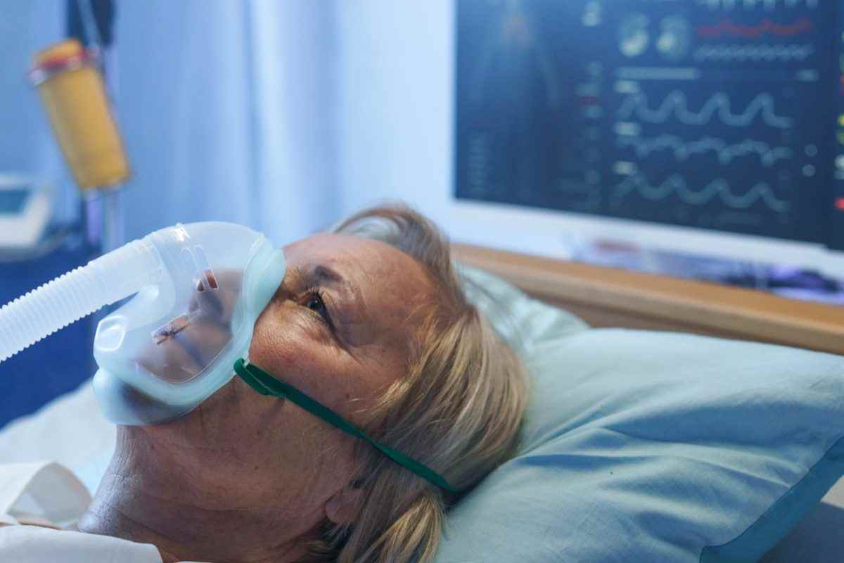 Covid-19-Patient mit Sauerstoffmaske im Bett im Krankenhaus