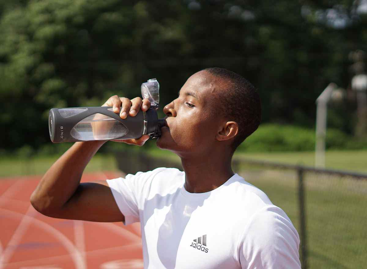 Sportler trinkt kaltes Wasser auf der Strecke