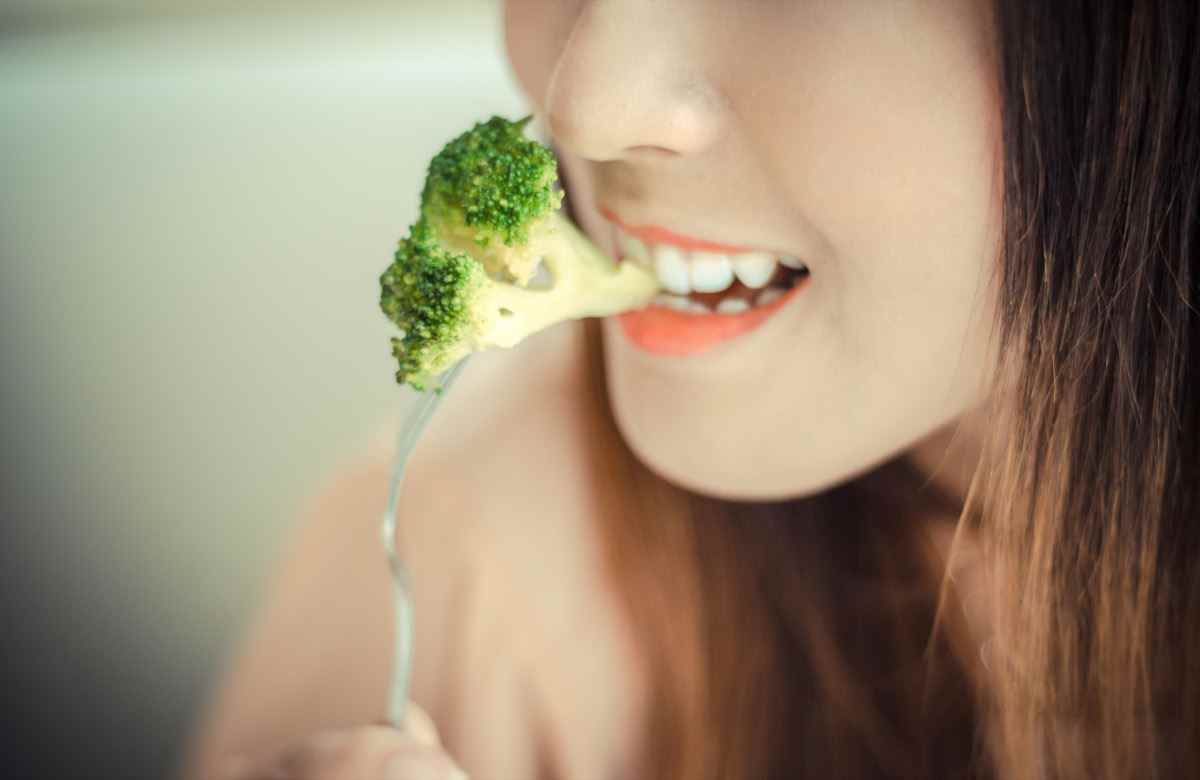 junge Frau, die Brokkoli isst