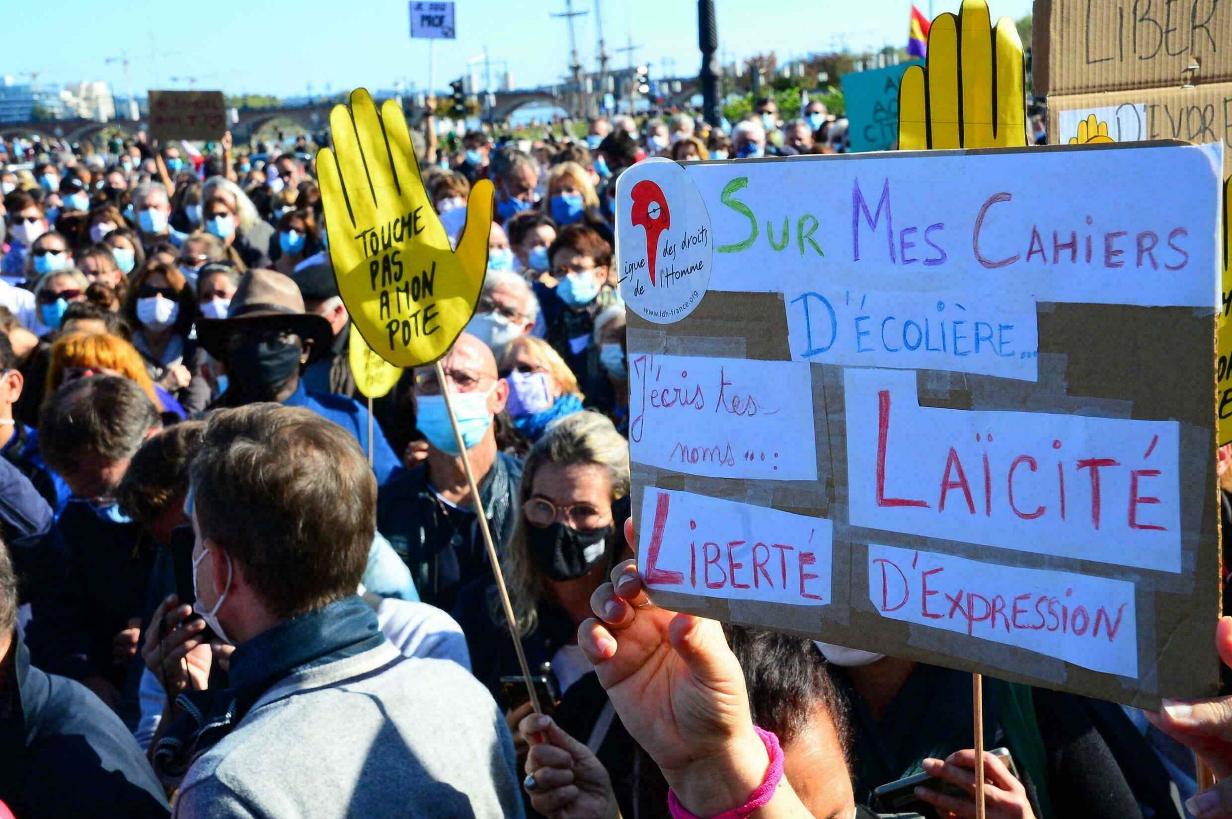 People display placards in support of laïcité, the French form of secularism designed to keep religion out of politics and education, at a demonstration in honour of Samuel Paty in Bordeaux on October 18, 2020.