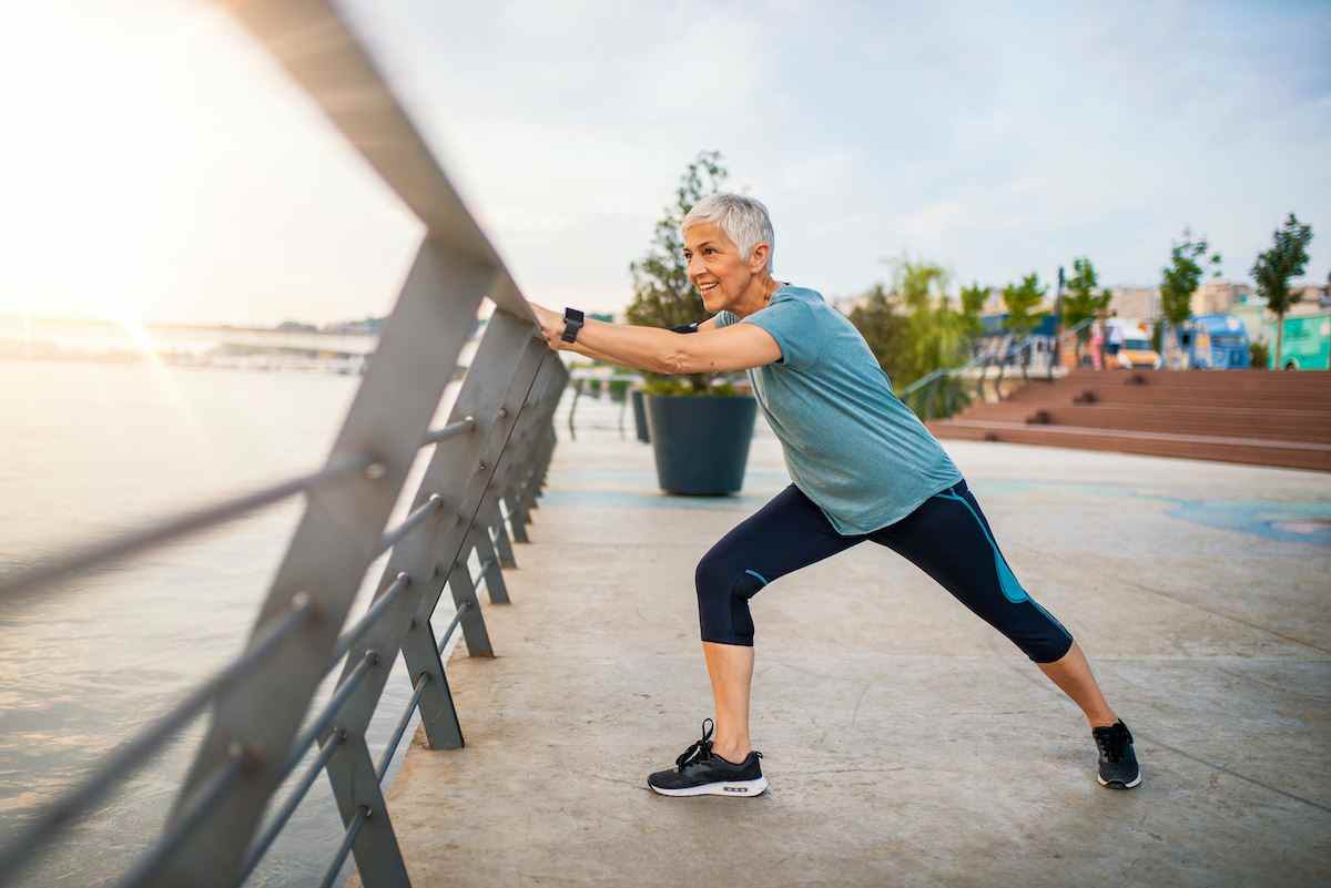 Eine ältere Frau dehnt sich während ihres Trainings aus.  Reife Frau, die trainiert.  Porträt einer fitten älteren Frau, die Dehnübungen im Park macht.  Ältere Sportlerin macht Dehnübungen
