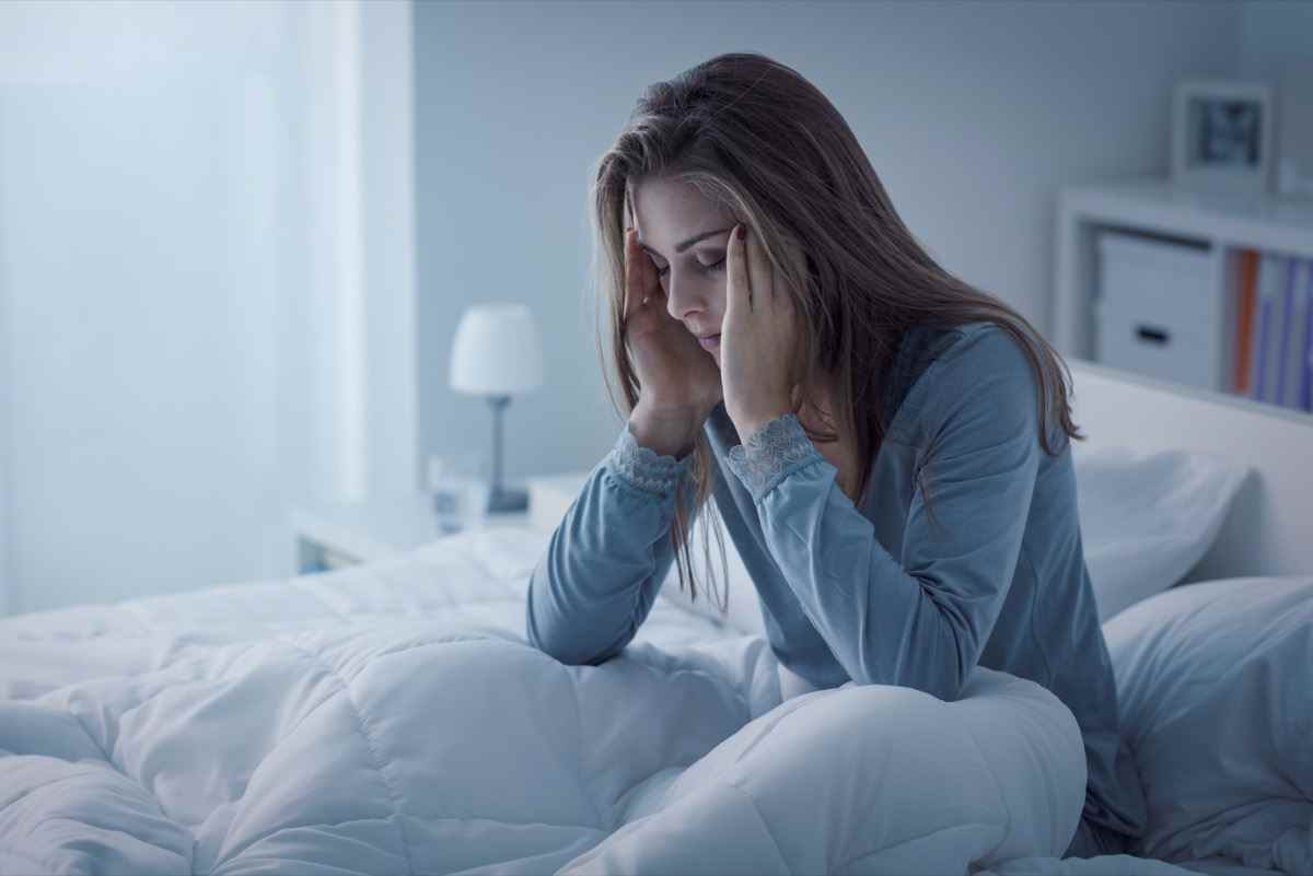 Depressive Frau wacht nachts auf, sie ist erschöpft und leidet an Schlaflosigkeit