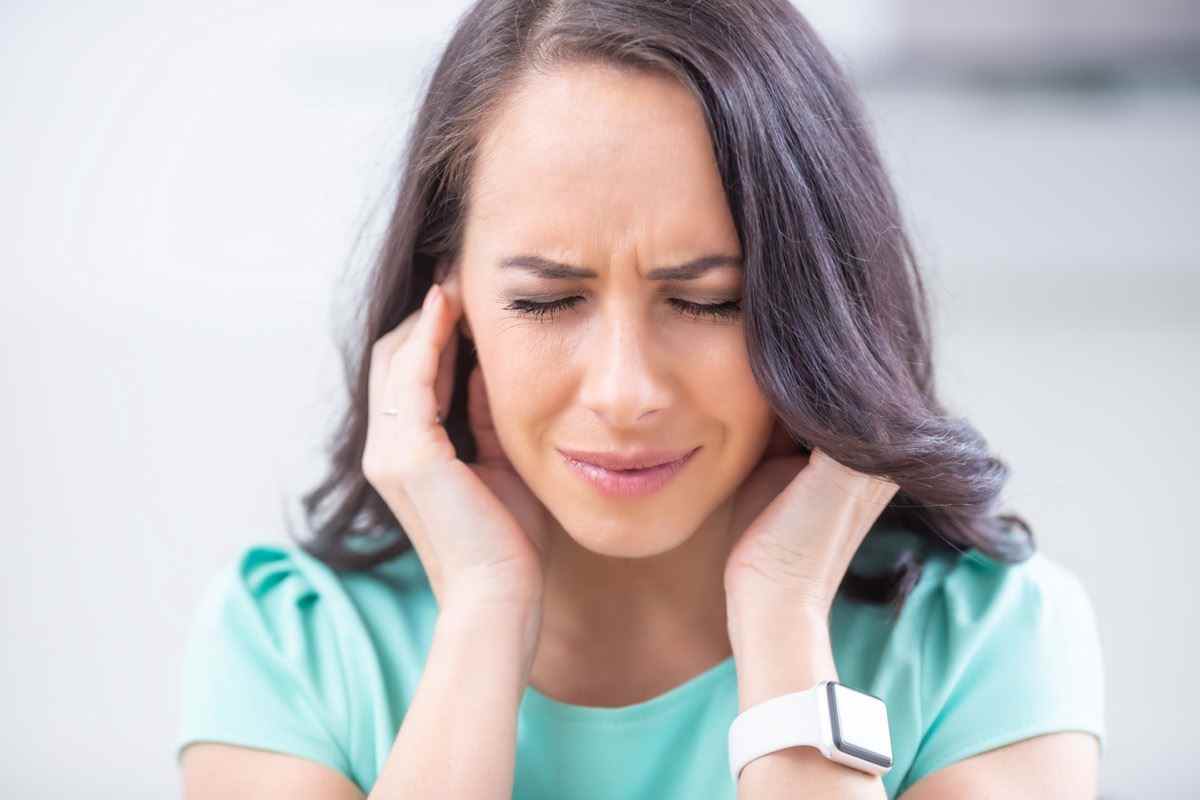 Junge Frau hat Kopfschmerzen, Migräne, Stress oder Tinnitus