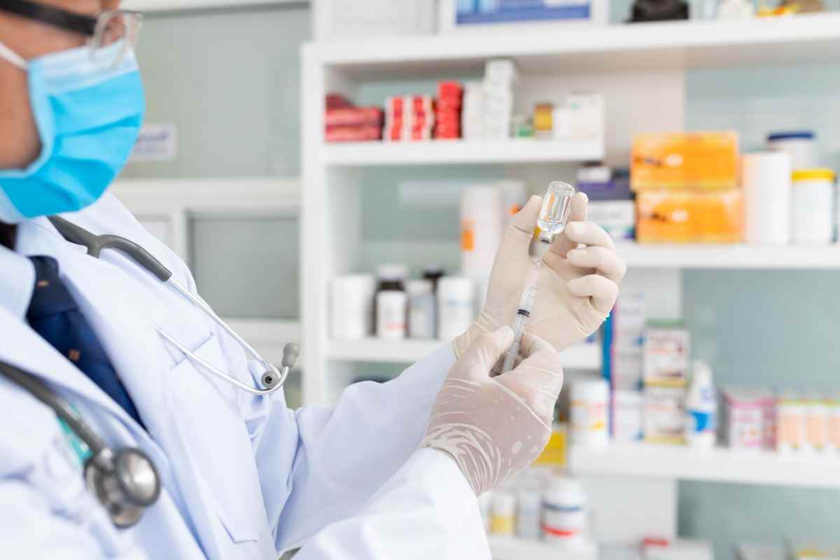 Hand des Arztes mit Spritze und Impfstoff