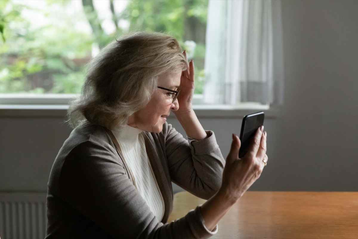 Rentner liest Nachricht auf dem Handy