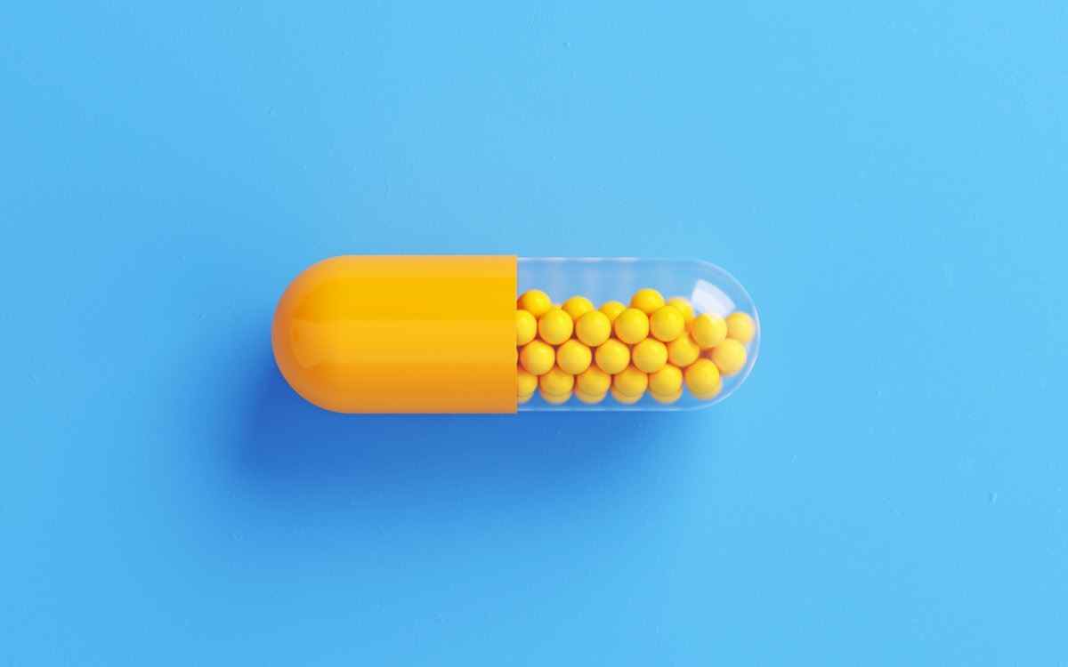 Gelbe Pille-Flasche auf blauem Hintergrund.