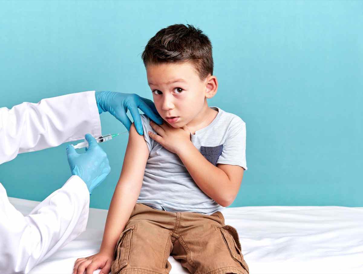 Der Kinderarzt impft das Kind.