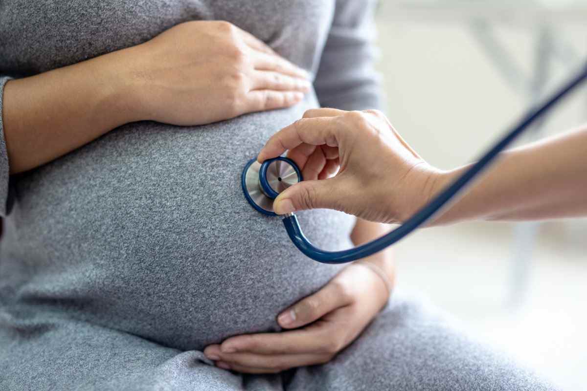 Ärztin überprüft schwangere Frau mit Stethoskop