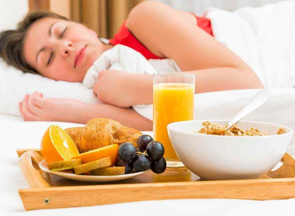 woman sleeping next to breakfast tray