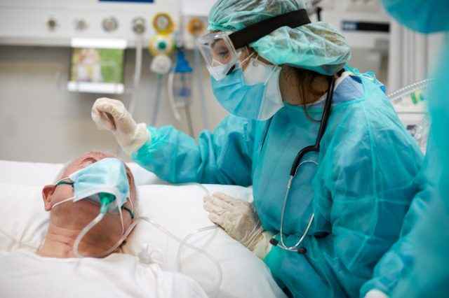 Krankenschwester tröstet einen Covid-Patienten auf der Intensivstation