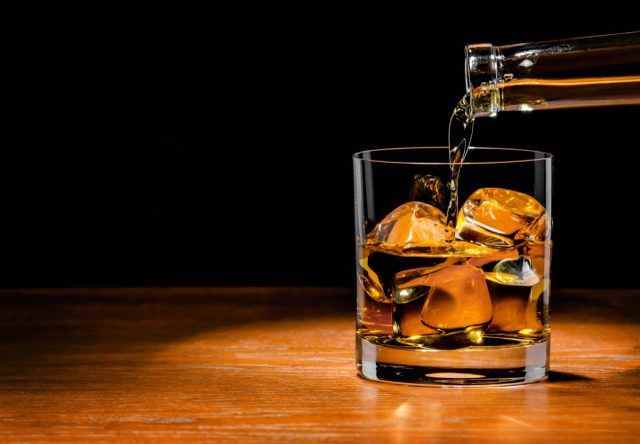 Whiskey-Drink ins Glas gießen