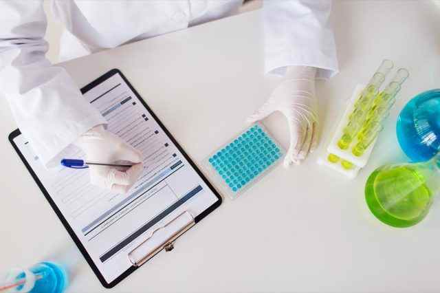 Wissenschaft, Chemie, Biologie, Medizin und Menschenkonzept - Nahaufnahme von Wissenschaftlern mit Testproben, die im klinischen Labor forschen