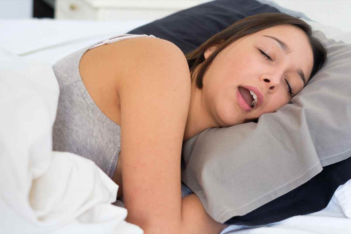 Müde Frau schnarcht laut im Bett