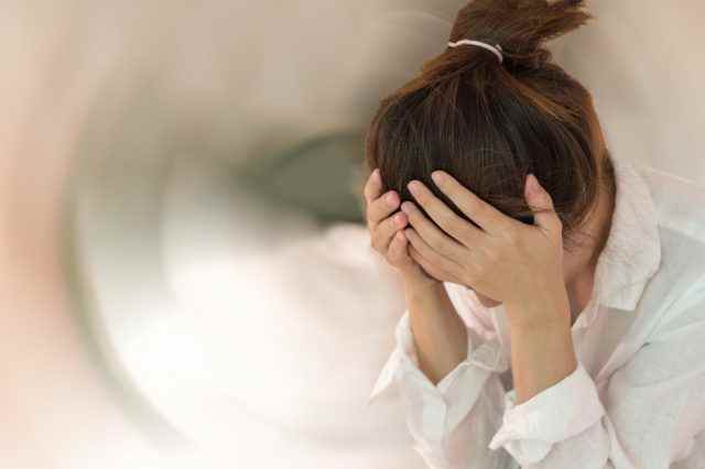Frauenhände auf seinem Kopf fallende Kopfschmerzen Schwindelgefühl von Drehschwindel bei Bewegung
