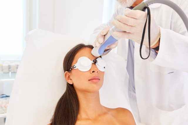 Hauterneuerung an der Stirn einer Frau mit dem fraktionierten Laser beim Hautarzt