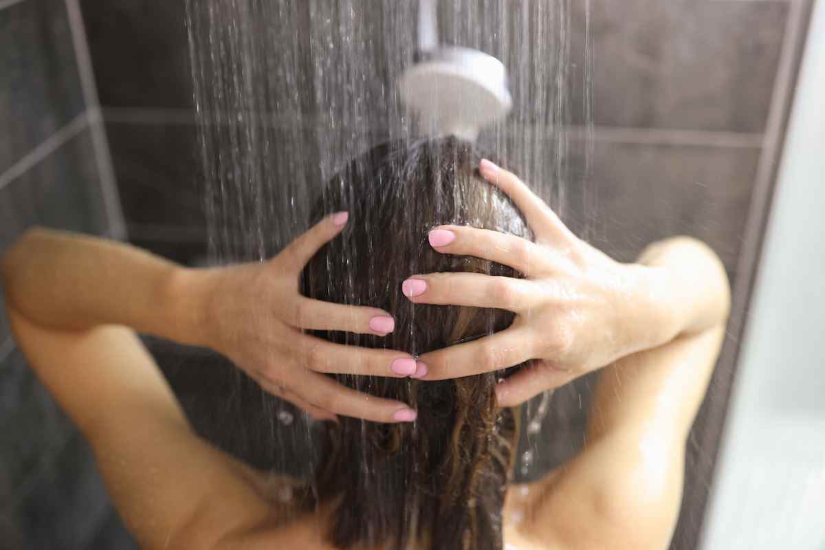 Frau duscht im Badezimmer.  Konzept der Hygieneregeln für Frauen