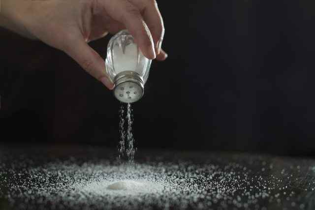 Salz hinzufügen.  Hintergrundbeleuchtung für Salz vom Salzstreuer.