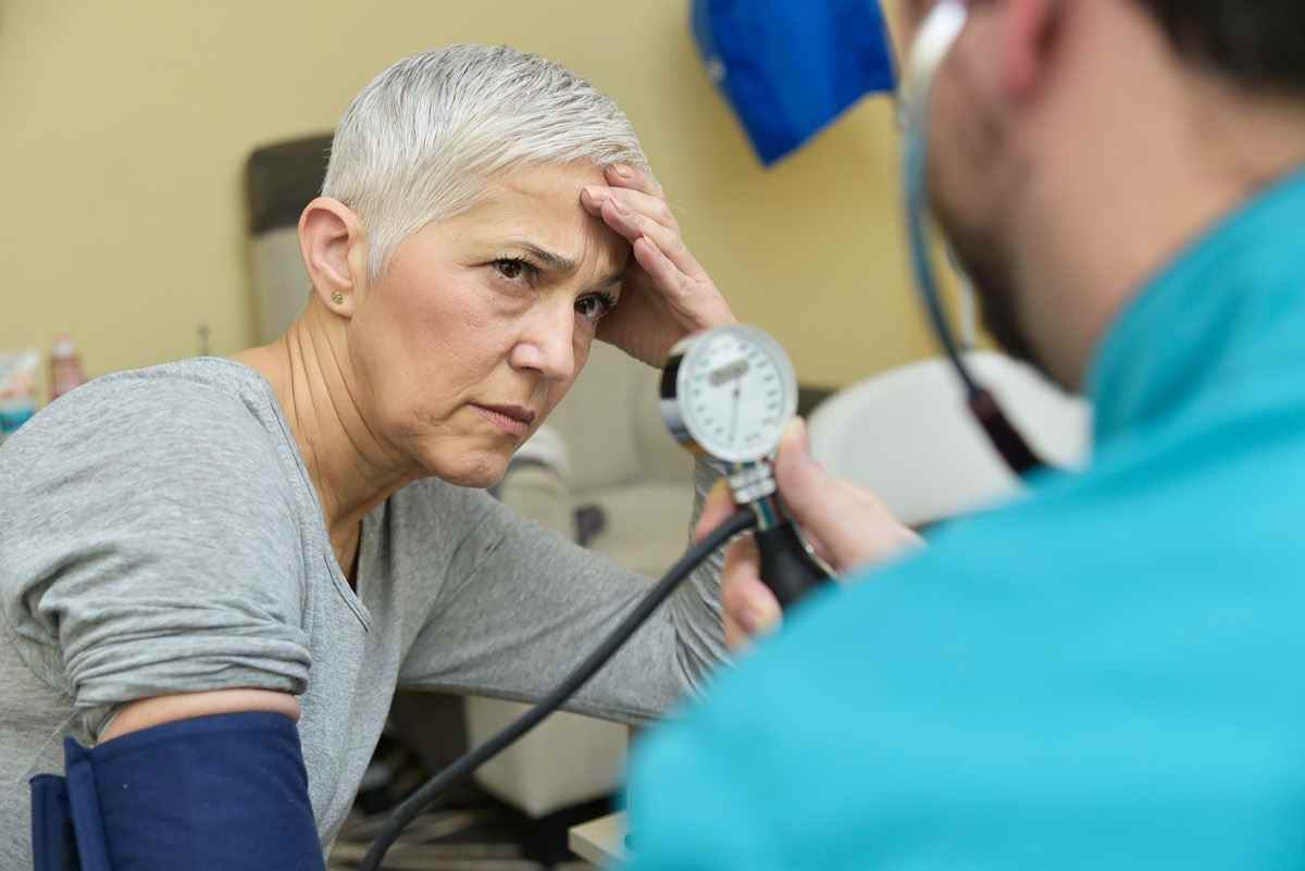 Ältere Dame, die von ihrem Arzt schlechte Nachrichten über ihren Blutdruck erhält