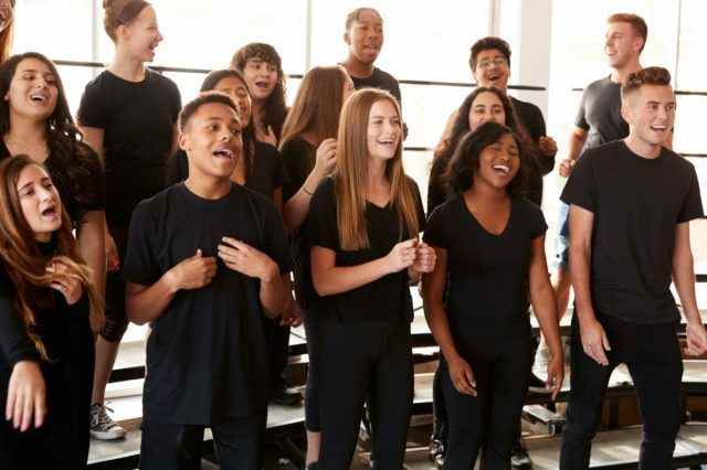 Männliche und weibliche Schüler singen im Chor an der Schule für darstellende Künste