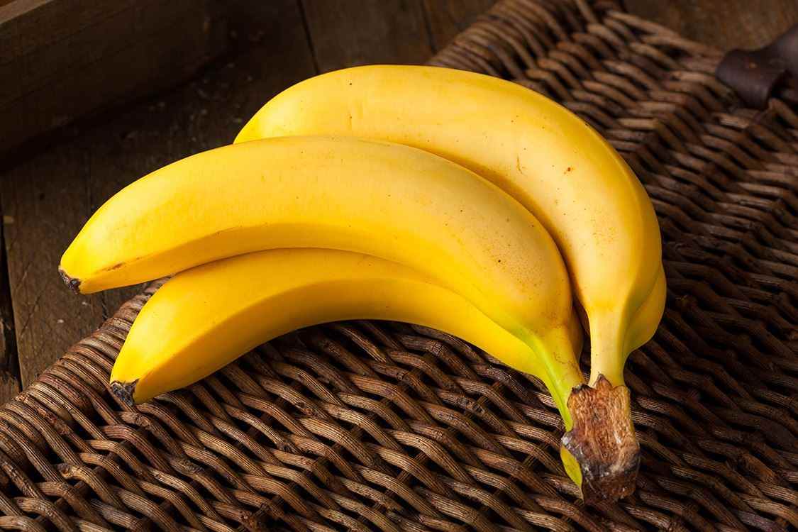 Bündel gelbe Bananen auf Korbhintergrund