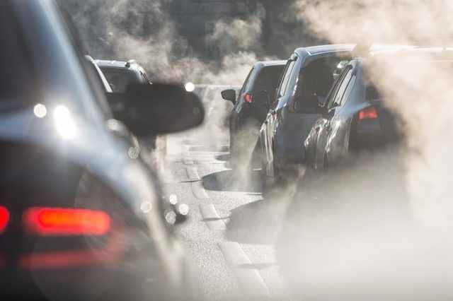 Verschwommene Silhouetten von Autos, die von Dampf aus den Auspuffrohren umgeben sind