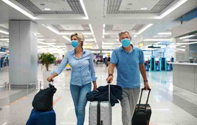 Ehepaar mittleren Alters an einem Flughafen während der Coronavirus-Pandemie.