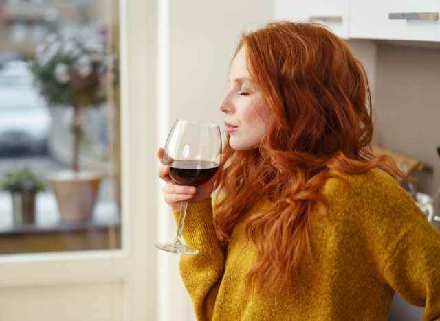 Frau trinkt zu Hause Weinalkohol