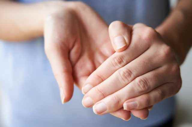 Nahaufnahme einer Frau, die ihre Hände mit Desinfektionsmittel reibt