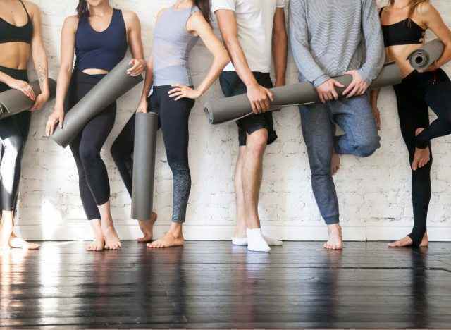 Gruppe von Menschen in Trainingskleidung mit Yogamatten