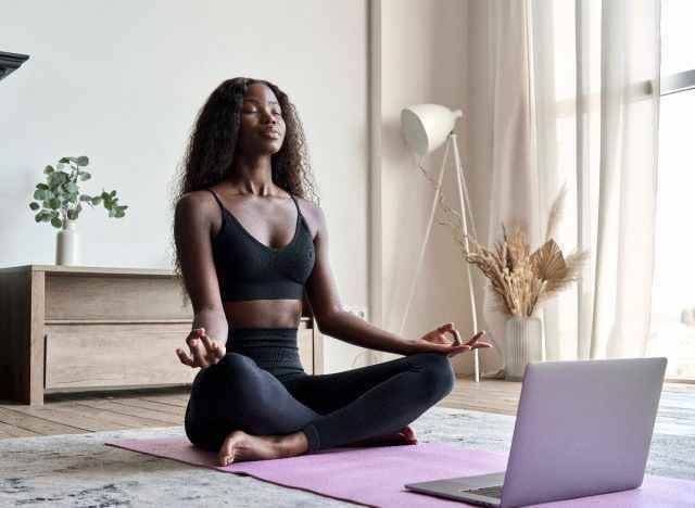 Frau meditiert friedlich während einer virtuellen Sitzung