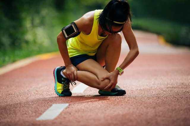 Läuferin, die unter Schmerzen bei Sportverletzungen leidet