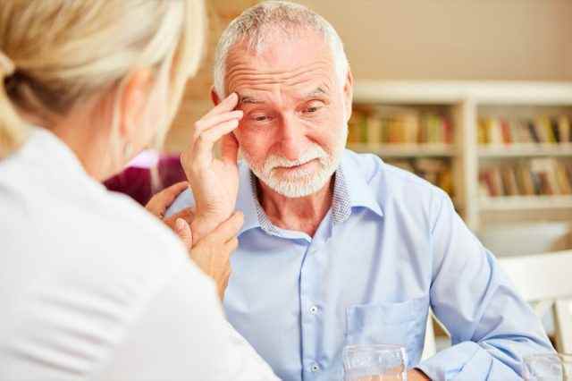 älterer Mann mit Demenz im Gespräch mit dem Arzt