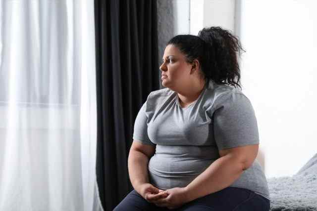Depressive übergewichtige Frau zu Hause im Bett