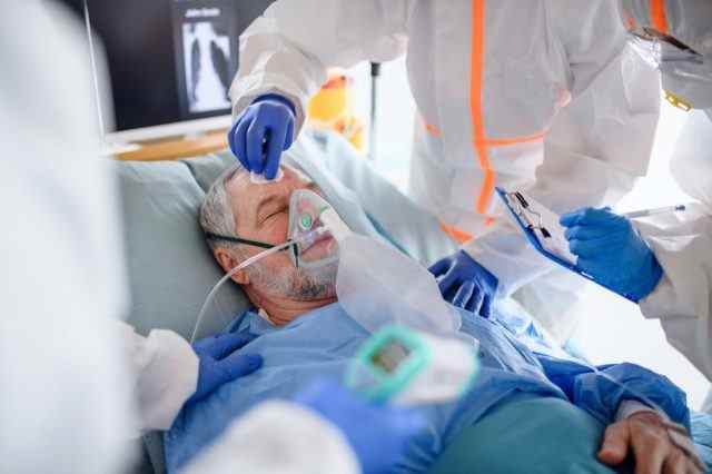 Infizierter Patient in Quarantäne, der im Krankenhaus im Bett liegt.