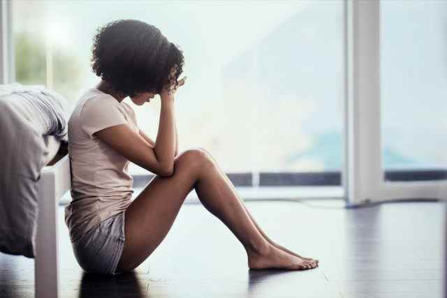 Aufnahme einer jungen Frau, die in ihrem Schlafzimmer an Depressionen leidet
