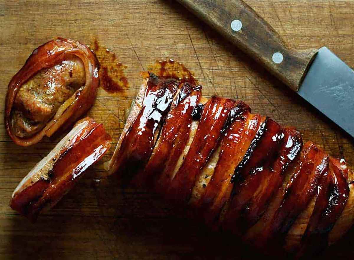 bacon wrapped pork tenderloin on cutting board