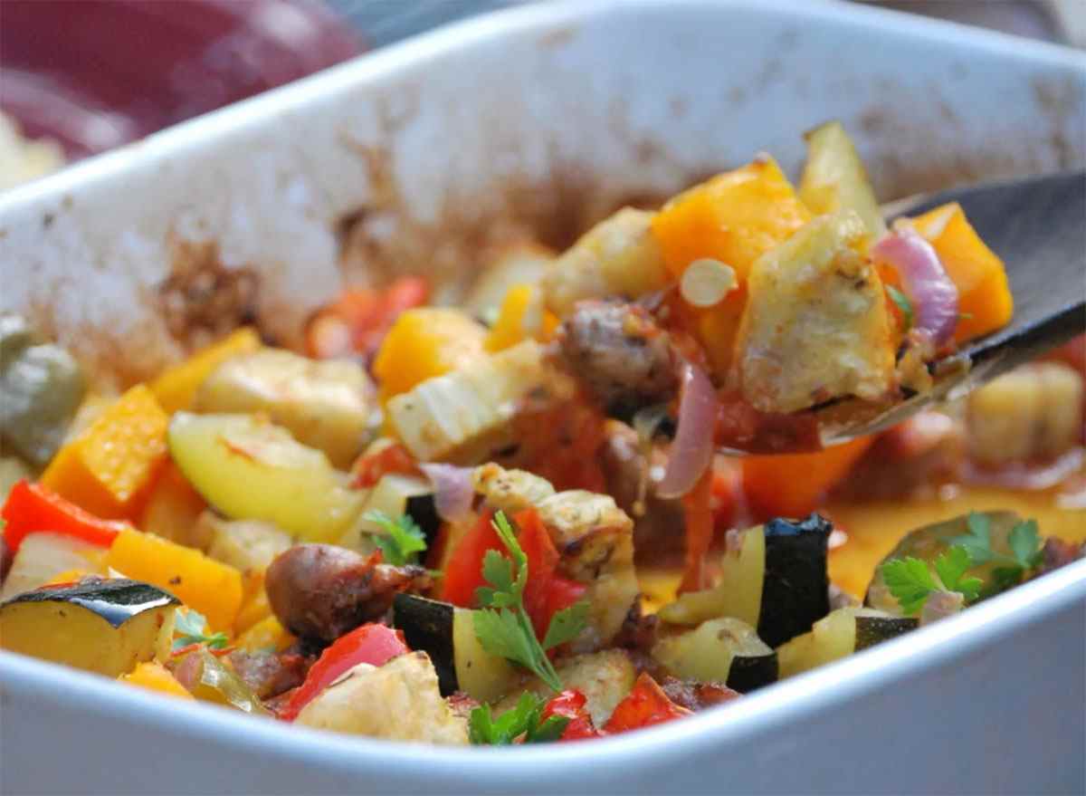 casserole dish with roasted vegetables and sausage