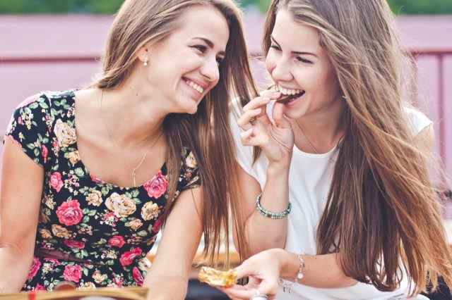 Zwei Freundinnen essen im Freien