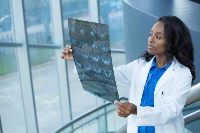 Nahaufnahmeporträt von intellektuellen Frauen im Gesundheitswesen mit weißem Laborkittel, Blick auf Ganzkörper-Röntgen-Röntgenbild, CT-Scan, MRI
