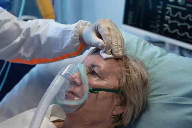 Nahaufnahme eines Covid-19-infizierten Patienten im Bett im Krankenhaus