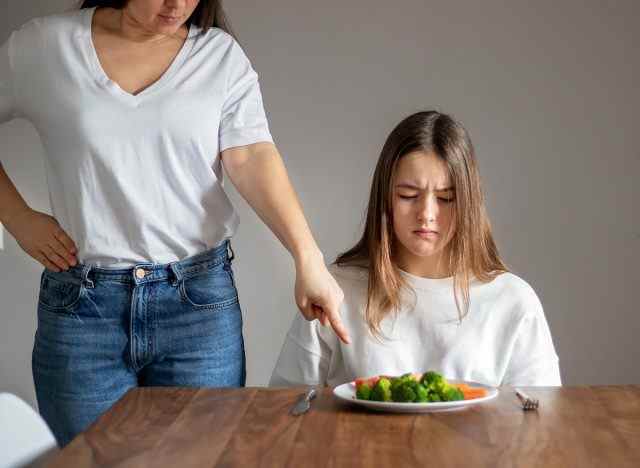 Eltern zwingen Kind, Gemüse zu essen