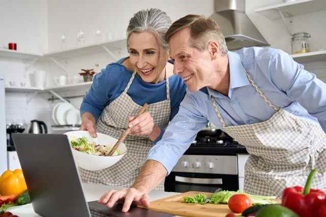 Älteres Paar, das eine gesunde Mahlzeit zum Abnehmen nach 60 kocht